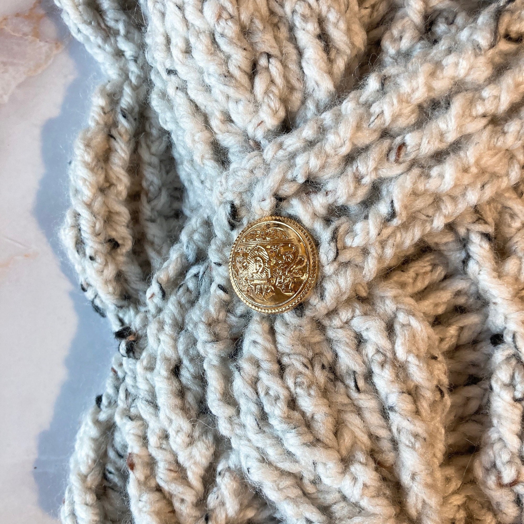 Écharpe feuilletée avec les boutons dorés