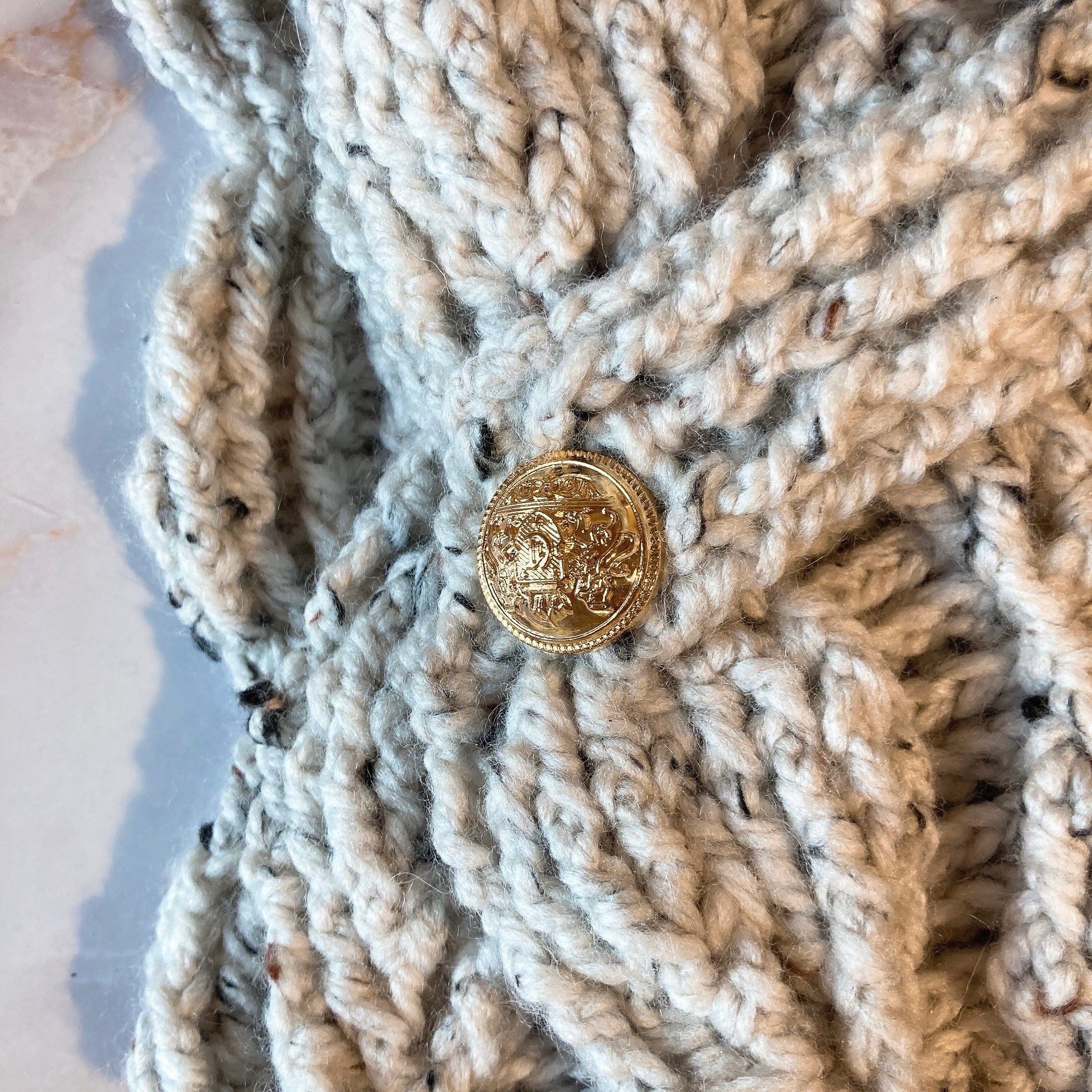 Écharpe feuilletée avec les boutons dorés