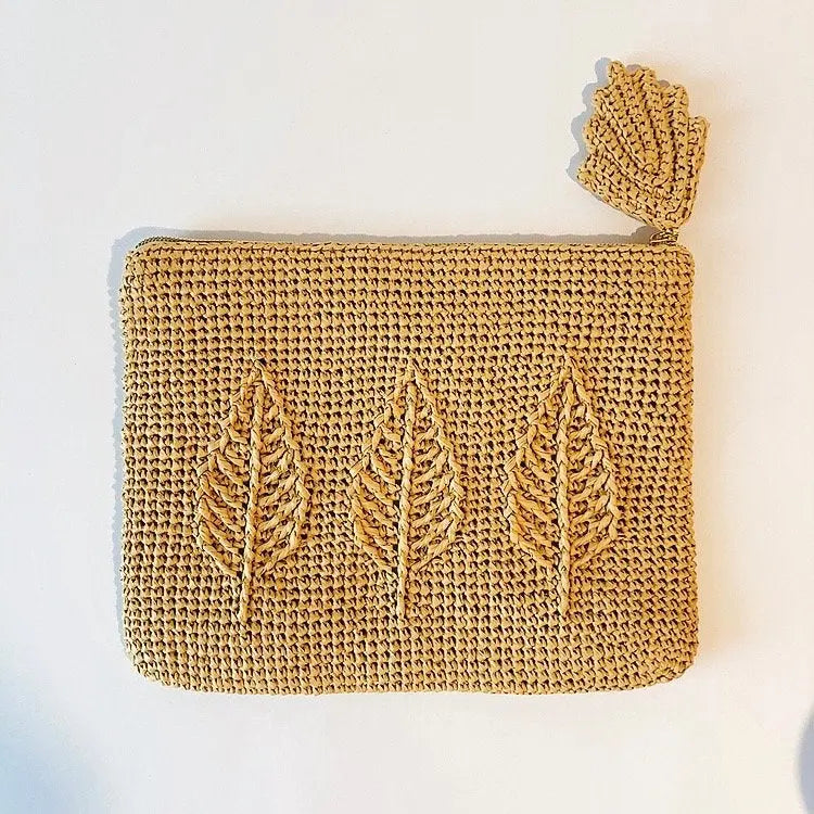 Pochette en raphia avec motif feuilles.